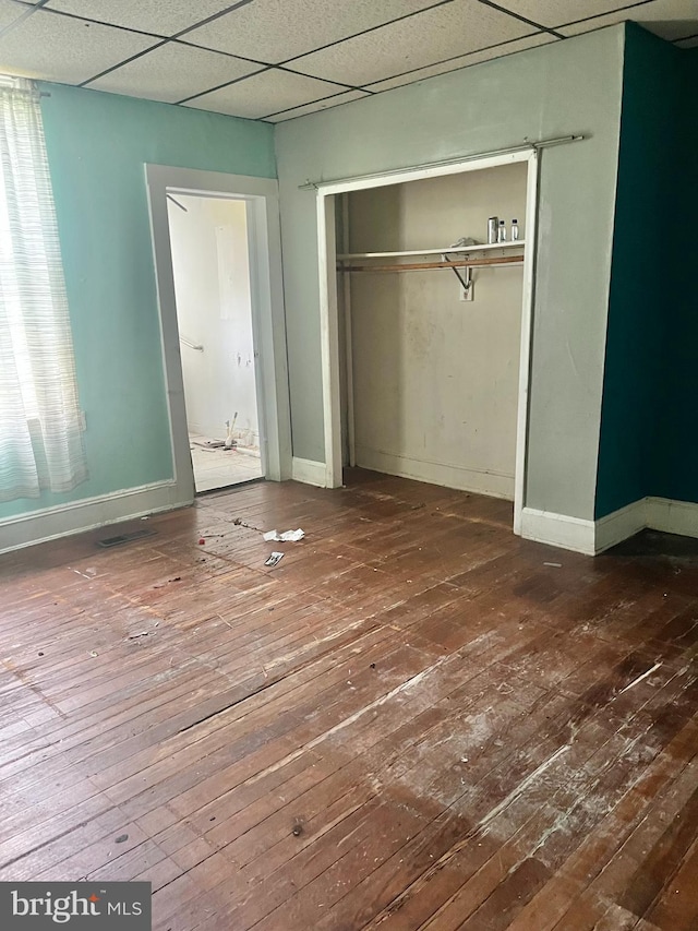 435 S Augusta Ave, Baltimore, MD 21229 - unfurnished bedroom featuring hardwood / wood-style floors, a paneled ceiling, baseboards, and a closet