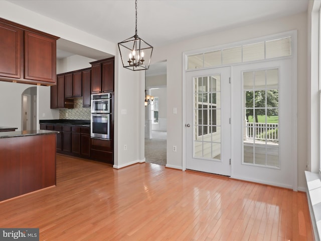 17494 Lethridge Cir, Round Hill, VA 20141 - kitchen featuring dark countertops, light wood finished floors, a chandelier, hanging light fixtures, and backsplash
