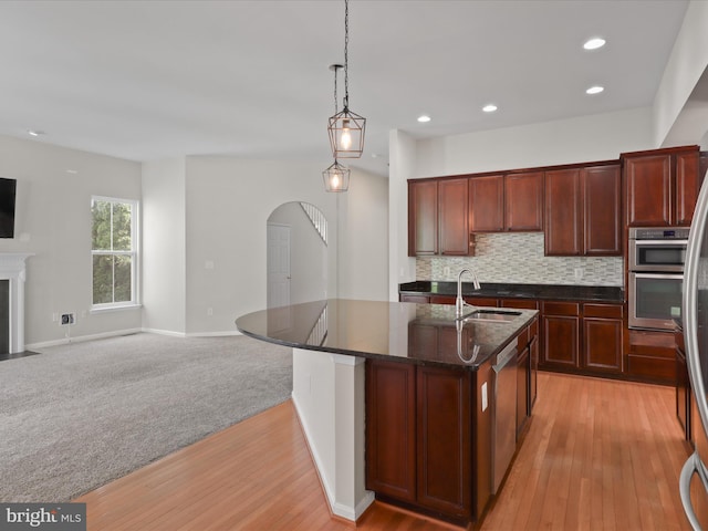 17494 Lethridge Cir, Round Hill, VA 20141 - kitchen with stainless steel appliances, open floor plan, decorative light fixtures, light wood-style flooring, and a center island with sink