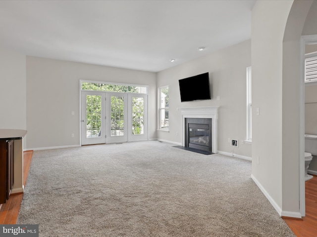 17494 Lethridge Cir, Round Hill, VA 20141 - unfurnished living room featuring a fireplace with flush hearth, arched walkways, and carpet flooring