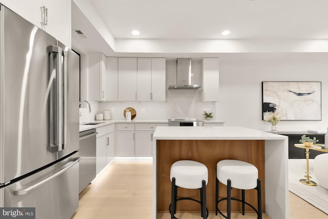 503 L St NE Unit B, Washington, DC 20002 - kitchen with stainless steel appliances, wall chimney range hood, a sink, a kitchen bar, and light countertops