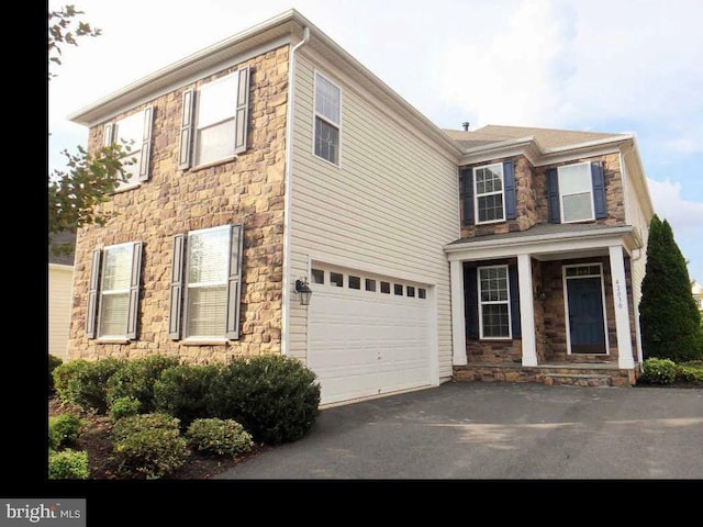 42030 Zircon Dr, Aldie, VA 20105 - view of front facade with stone siding, an attached garage, and driveway