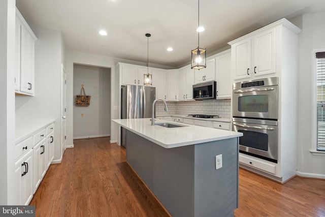 42030 Zircon Dr, Aldie, VA 20105 - kitchen featuring stainless steel appliances, a sink, backsplash, wood finished floors, and recessed lighting