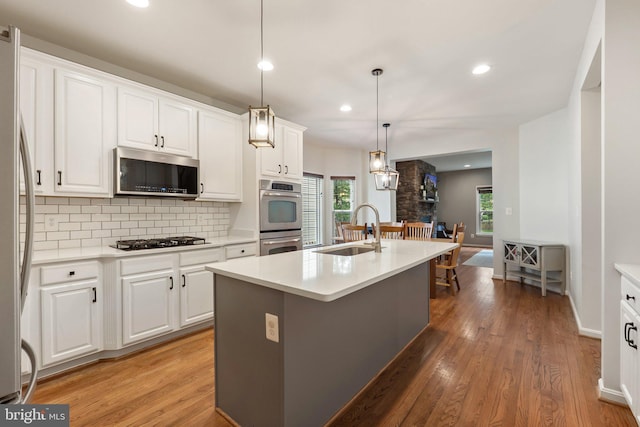 42030 Zircon Dr, Aldie, VA 20105 - kitchen with appliances with stainless steel finishes, a sink, tasteful backsplash, light wood-type flooring, and healthy amount of natural light