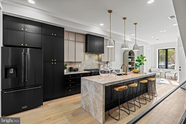 1407 1st St NW Unit 1, Washington, DC 20001 - kitchen featuring high end black fridge, a sink, dark cabinetry, light wood finished floors, and crown molding