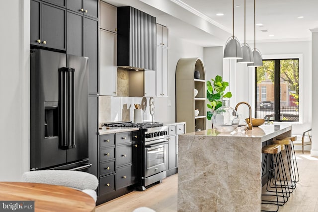 1407 1st St NW Unit 1, Washington, DC 20001 - kitchen featuring high quality appliances, light stone counters, ornamental molding, wall chimney range hood, and an island with sink