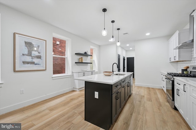 642 S 51st St, Philadelphia, PA 19143 - kitchen with gas stove, a sink, light wood-type flooring, light countertops, and a center island with sink