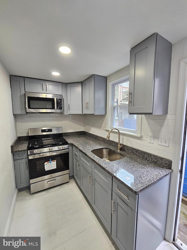 3173 Salmon St, Philadelphia, PA 19134 - kitchen featuring stainless steel appliances, gray cabinetry, a sink, and backsplash
