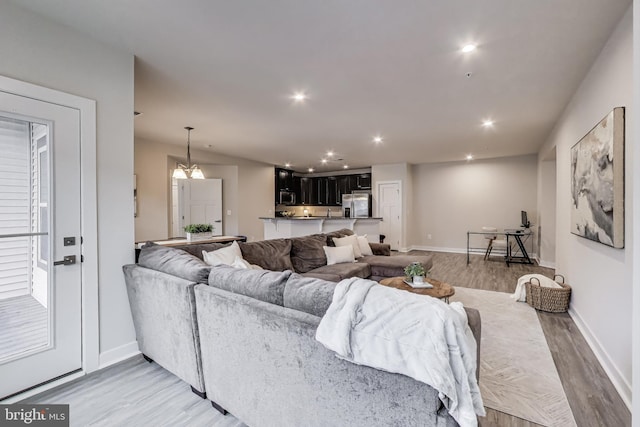 living room featuring light wood-style floors, baseboards, and recessed lighting