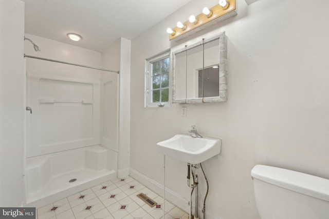 full bath with toilet, a shower, baseboards, tile patterned flooring, and a sink