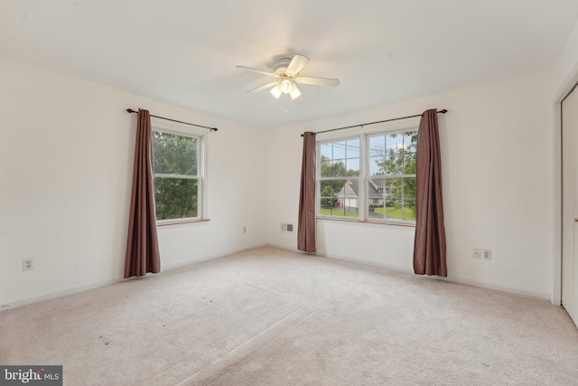 carpeted empty room with a ceiling fan