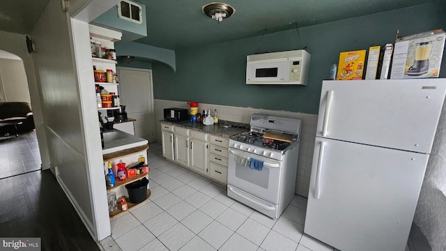 2209 Brighton St, Philadelphia, PA 19149 - kitchen featuring white appliances, arched walkways, open shelves, tile walls, and white cabinetry