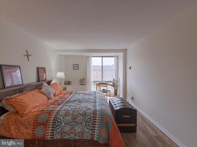 bedroom with wood finished floors and baseboards