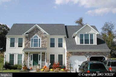 view of front of property featuring stone siding and a garage
