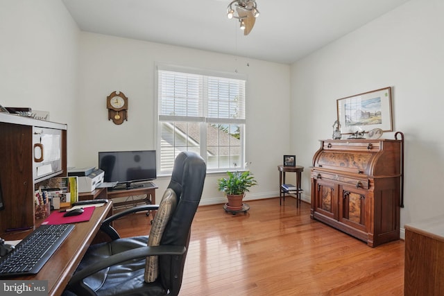 office with light wood-style flooring and baseboards