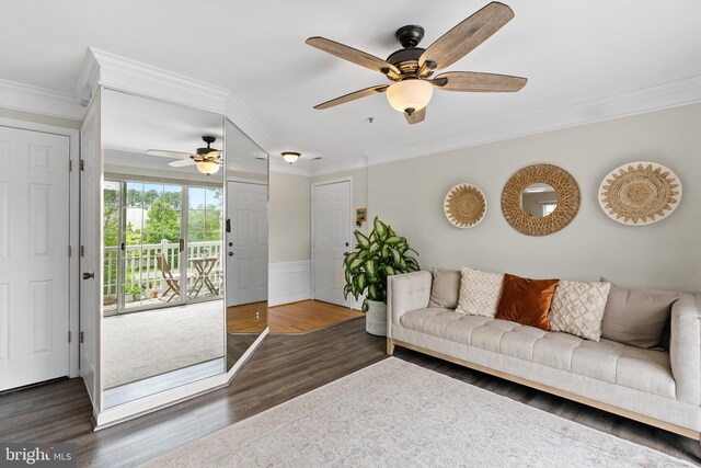 living area with ceiling fan, ornamental molding, wood finished floors, and a wainscoted wall