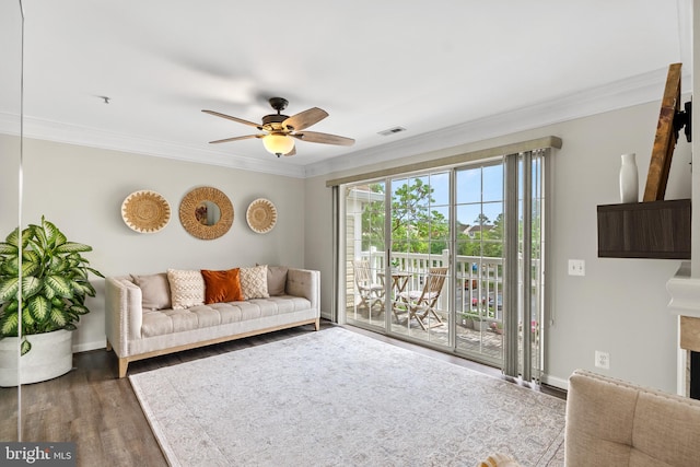 living room with ornamental molding, a ceiling fan, wood finished floors, and baseboards