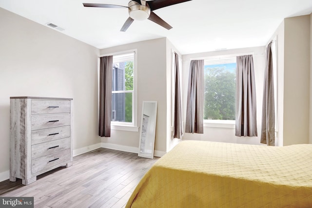 bedroom with light wood-style flooring, baseboards, and ceiling fan