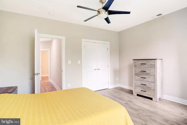 bedroom with light wood finished floors, a closet, baseboards, and a ceiling fan
