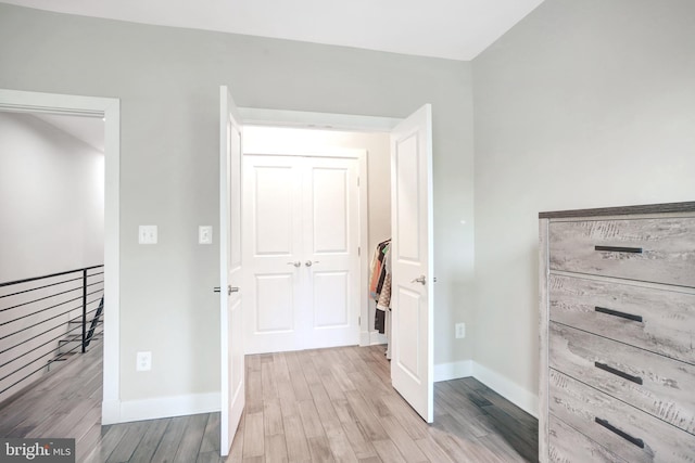 hallway with wood finished floors and baseboards