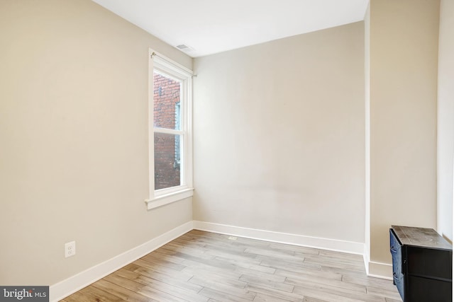 unfurnished room with baseboards and light wood-style flooring