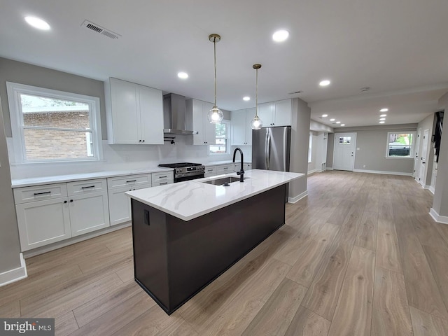5209 10th Pl S, Arlington, VA 22204 - kitchen featuring a sink, appliances with stainless steel finishes, wall chimney exhaust hood, light wood finished floors, and recessed lighting