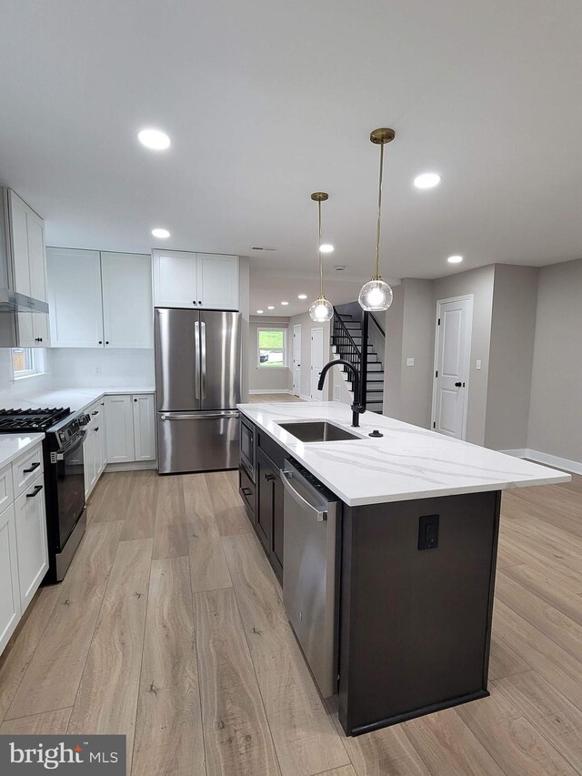 5209 10th Pl S, Arlington, VA 22204 - kitchen with appliances with stainless steel finishes, a sink, light wood-type flooring, a center island with sink, and recessed lighting