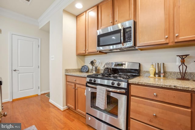 444 Exchange Ave Unit 444, Gaithersburg, MD 20878 - kitchen featuring stainless steel appliances, ornamental molding, light wood-type flooring, light stone counters, and baseboards