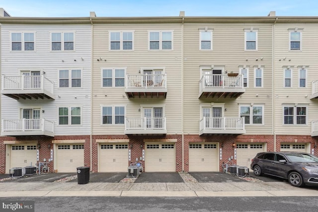 444 Exchange Ave Unit 444, Gaithersburg, MD 20878 - back of property with brick siding, driveway, an attached garage, and central air condition unit