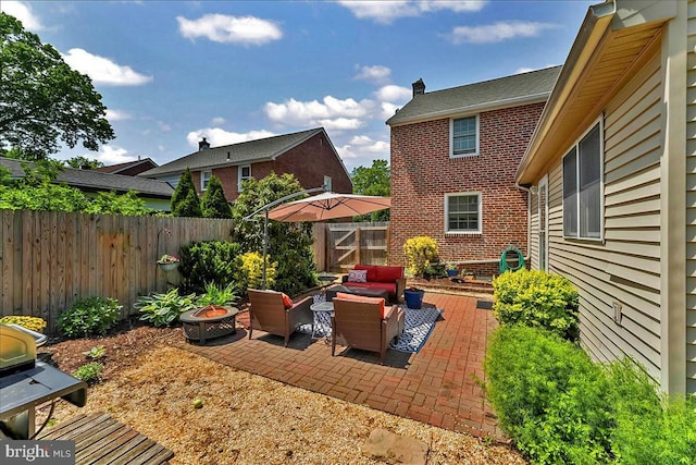 view of patio featuring a fenced backyard and an outdoor living space with a fire pit