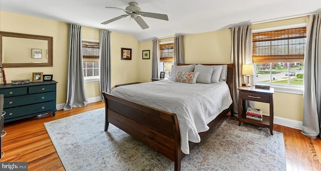 bedroom featuring baseboards, wood finished floors, ceiling fan, and vaulted ceiling