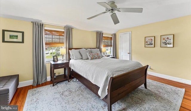 bedroom with baseboards, light wood-type flooring, and a ceiling fan