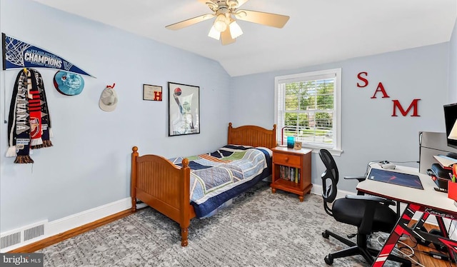 bedroom featuring lofted ceiling, a ceiling fan, baseboards, wood finished floors, and an office area