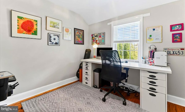 office space featuring light wood-style flooring, lofted ceiling, and baseboards