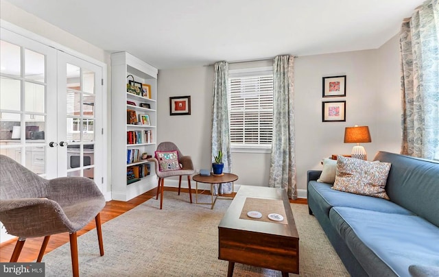 sitting room with wood finished floors, healthy amount of natural light, french doors, and baseboards