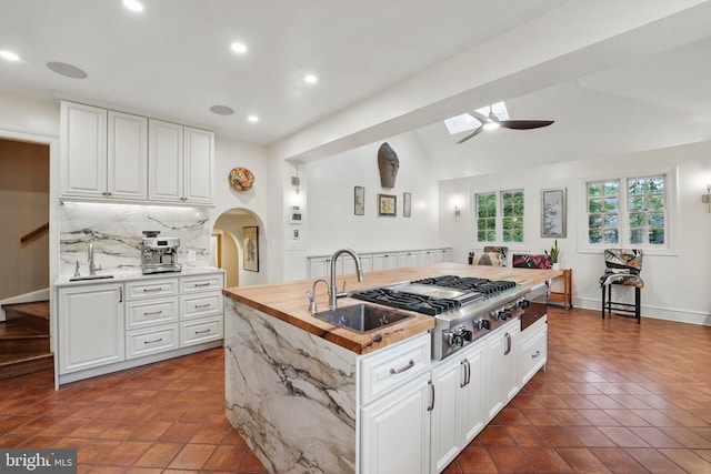 4301 Forest Ln NW, Washington, DC 20007 - kitchen with ceiling fan, arched walkways, stainless steel gas cooktop, a sink, and backsplash