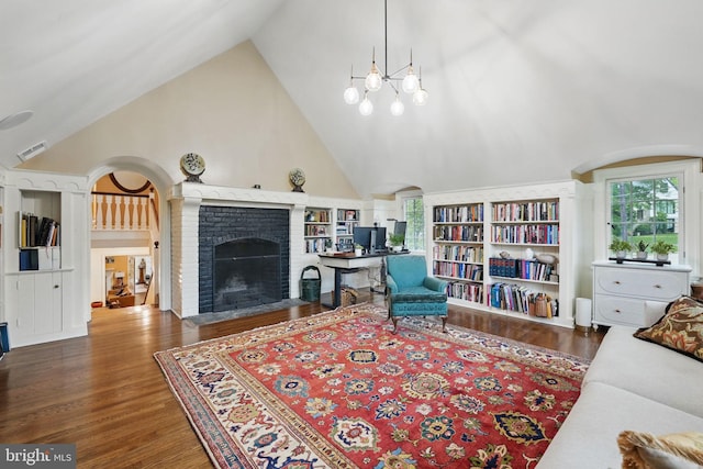 4301 Forest Ln NW, Washington, DC 20007 - living room with high vaulted ceiling, wood finished floors, a brick fireplace, built in features, and arched walkways