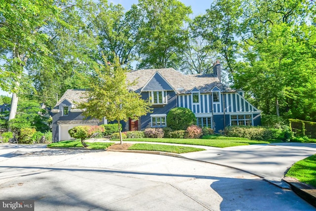 4301 Forest Ln NW, Washington, DC 20007 - tudor house featuring a front yard, a chimney, and driveway