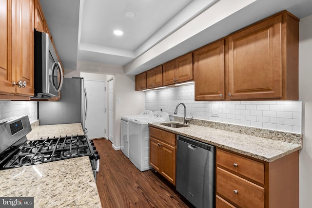 10234 Prince Pl Unit 17-T2, Upper Marlboro, MD 20774 - kitchen featuring stainless steel appliances, washing machine and dryer, a sink, dark wood-style floors, and brown cabinetry