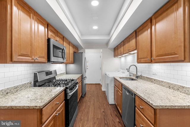 10234 Prince Pl Unit 17-T2, Upper Marlboro, MD 20774 - kitchen featuring stainless steel appliances, washer and clothes dryer, dark wood-style floors, a sink, and backsplash