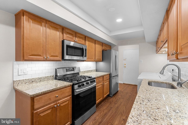 10234 Prince Pl Unit 17-T2, Upper Marlboro, MD 20774 - kitchen with appliances with stainless steel finishes, a sink, light stone countertops, dark wood-style flooring, and a tray ceiling