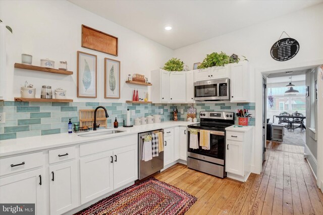 242 E Walnut St, Lancaster, PA 17602 - kitchen with stainless steel appliances, open shelves, a sink, tasteful backsplash, and white cabinets