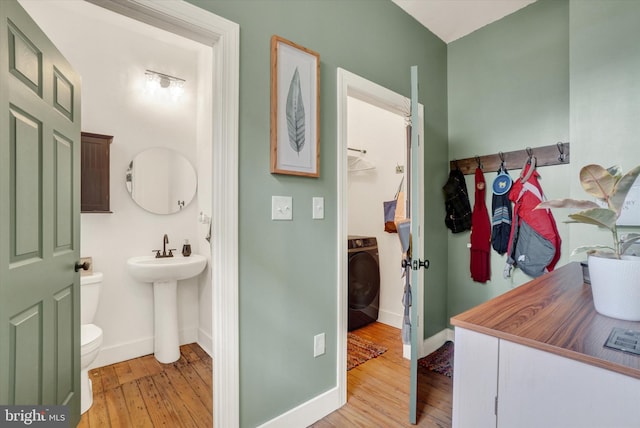 242 E Walnut St, Lancaster, PA 17602 - half bathroom featuring washer / clothes dryer, hardwood / wood-style flooring, baseboards, toilet, and a sink