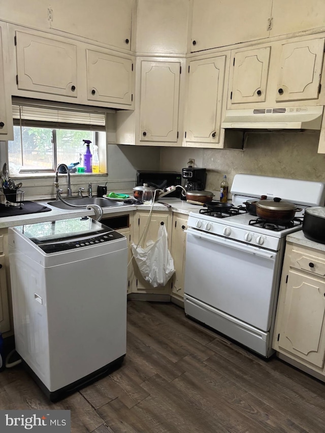 3857 N Marshall St, Philadelphia, PA 19140 - kitchen with white range with gas stovetop, under cabinet range hood, washer / dryer, dark wood-style floors, and light countertops