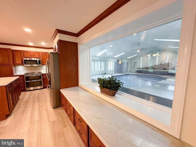 1392 Kutz Dr, Pottstown, PA 19465 - kitchen with stainless steel appliances, brown cabinetry, backsplash, light wood-style floors, and ceiling fan