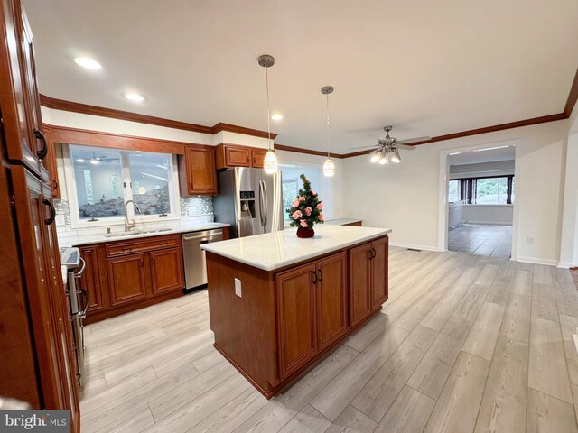 1392 Kutz Dr, Pottstown, PA 19465 - kitchen featuring appliances with stainless steel finishes, brown cabinets, ceiling fan, light wood-style flooring, and ornamental molding