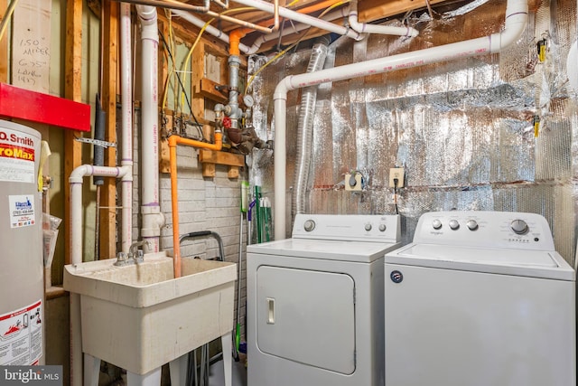 laundry room featuring separate washer and dryer, gas water heater, and concrete block wall