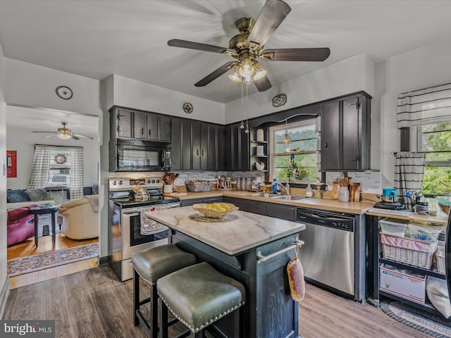 9 S Laurel Ave, Berkeley Springs, WV 25411 - kitchen featuring stainless steel appliances, a sink, a ceiling fan, light countertops, and decorative backsplash