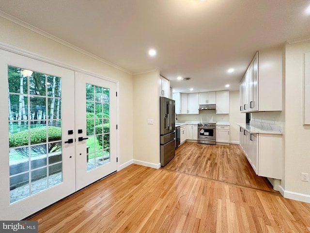 kitchen featuring stainless steel appliances, light wood-style floors, french doors, baseboards, and under cabinet range hood
