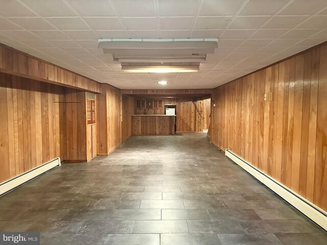 finished below grade area with a baseboard heating unit and wood walls